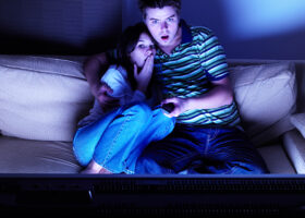 Ungt par ser skräckfilm på tv