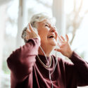 glad kvinna lyssnar på musik