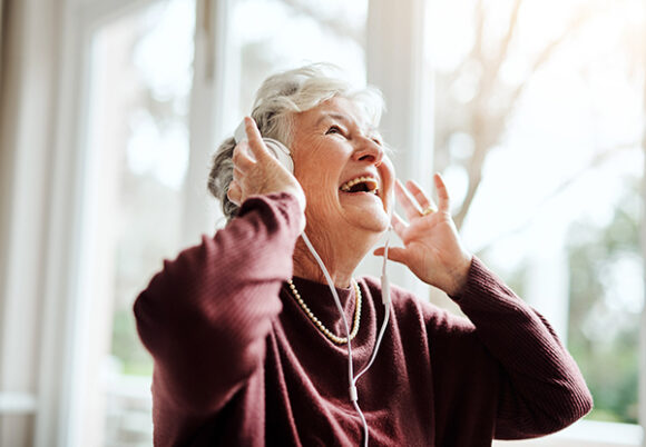 glad kvinna lyssnar på musik
