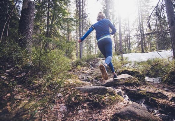 kvinna springer i skogen