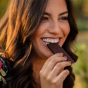 Leende kvinna äter choklad