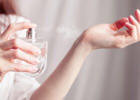 Kvinna sprutar parfym på handleden
