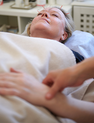 Terapeut tar pulsen på kvinnlig patient