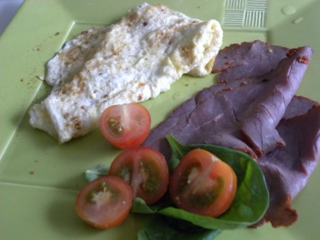 En vanlig frukost som består av rostbiff och omelett