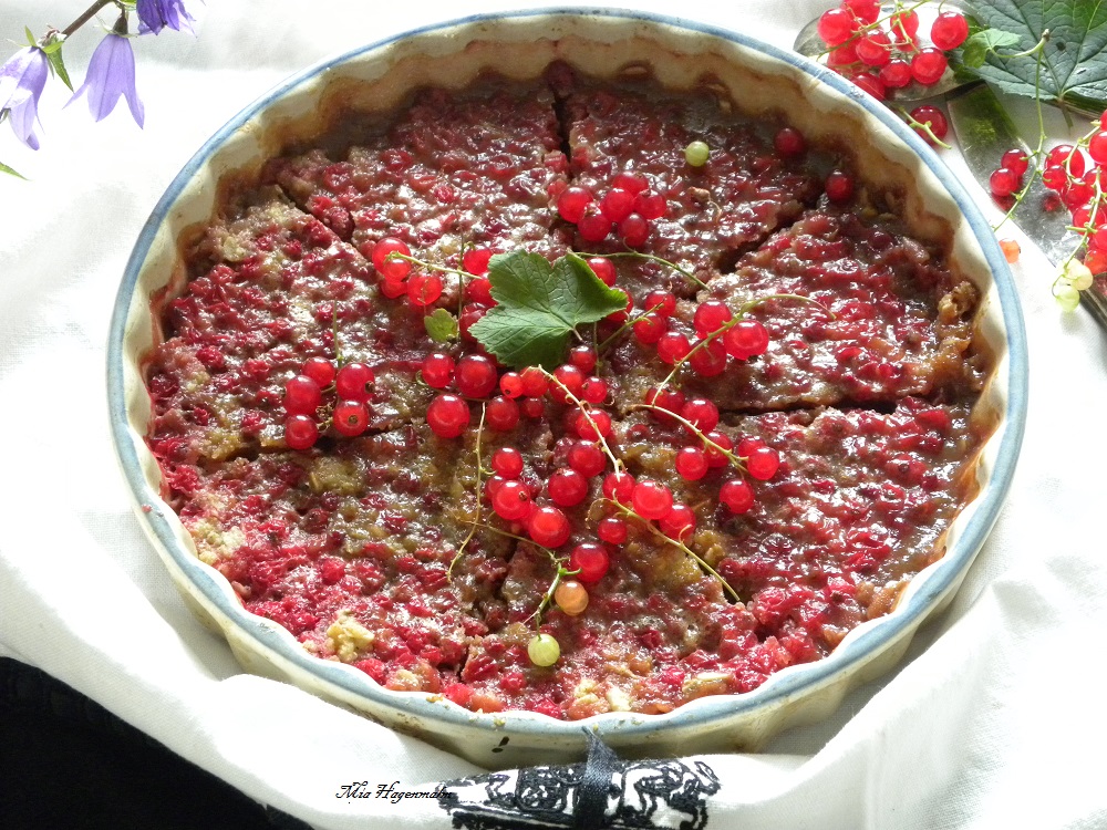 Vinbärspaj med kolasås i en pajform dekorerad med röda vinbär