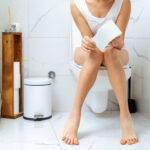 Kvinna sitter på toaletten