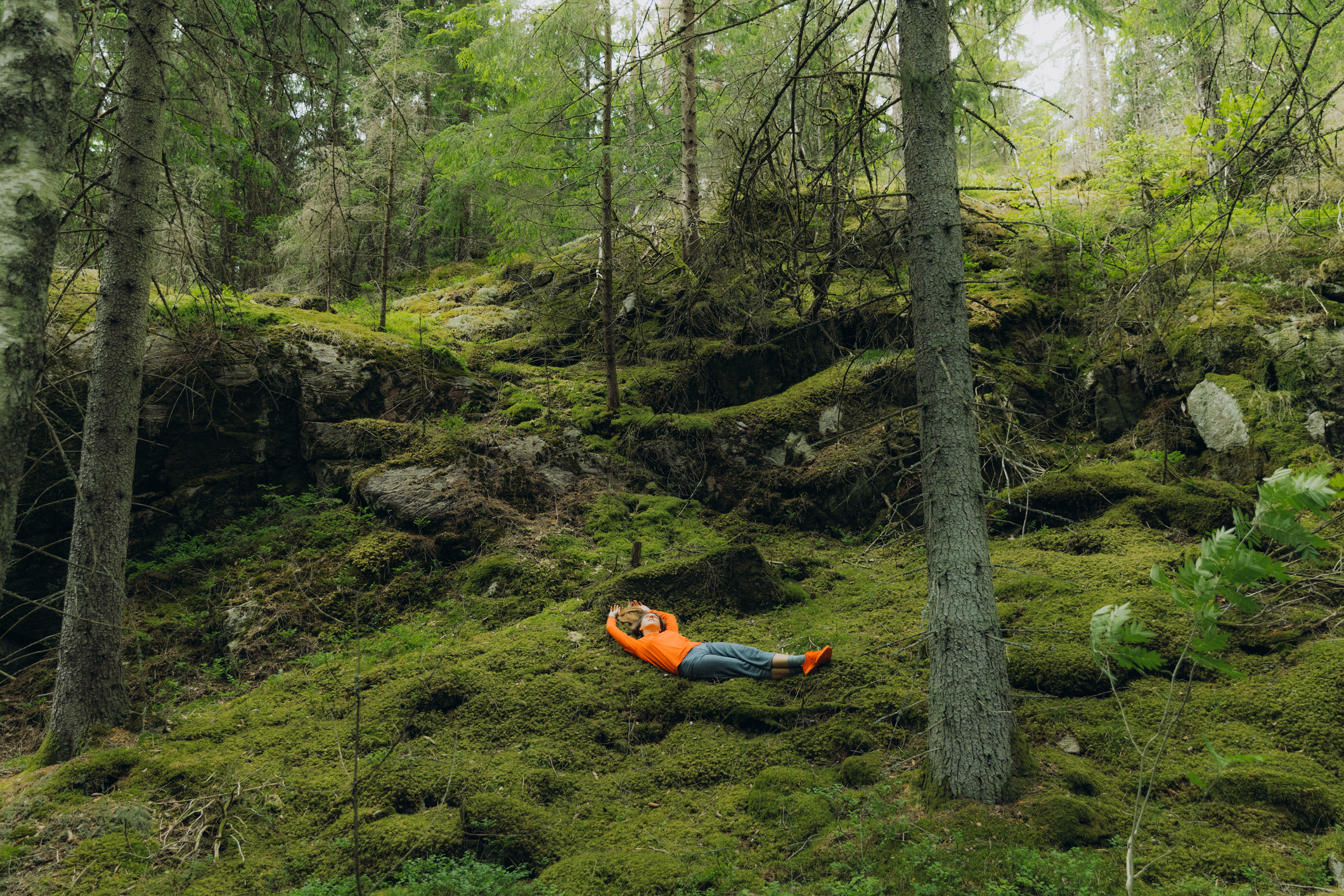 Kvinna ligger på marken i skogen