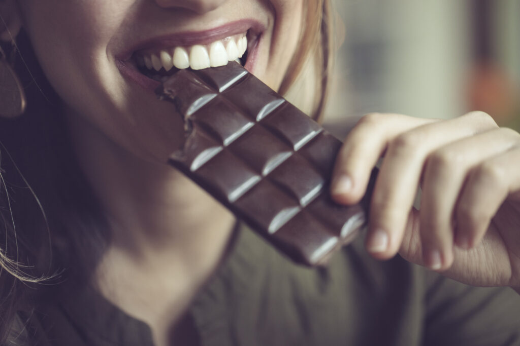 Närbild på kvinna som äter mörk choklad