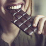 Närbild på kvinna som äter mörk choklad