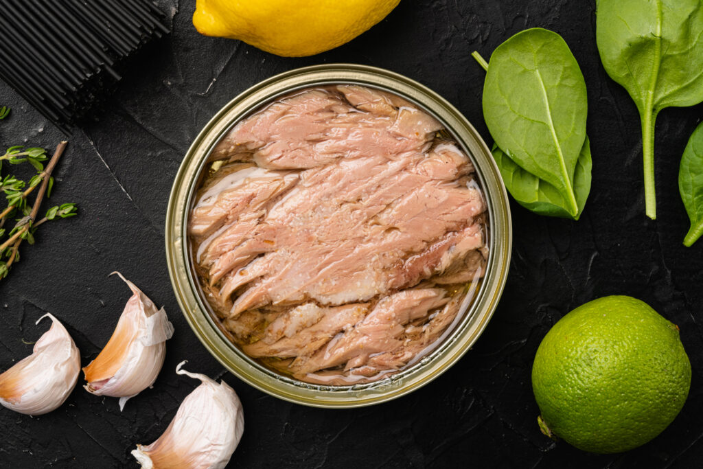 Tonfisk på burk med vitlök och örter runt om