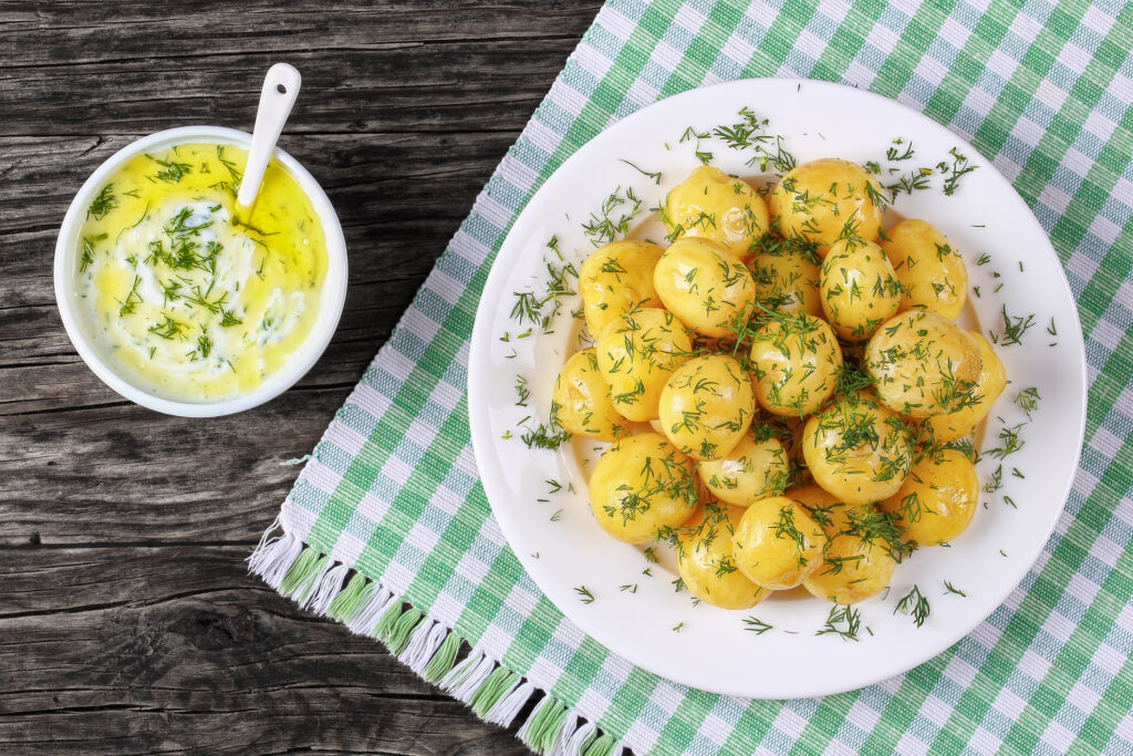 Skål med färskpotatis på rutig duk