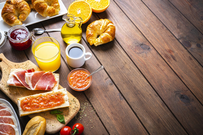Frukostbord med kaffe, juice, croisannat, apelsin m.m
