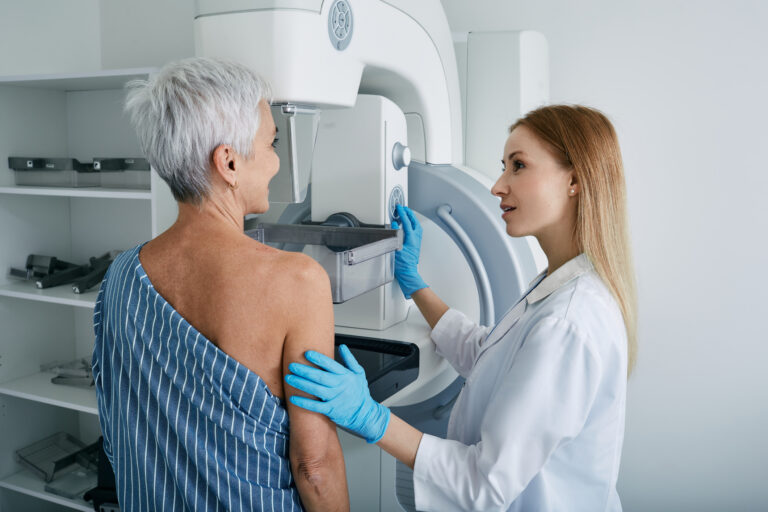 Äldre kvinna på mammografi