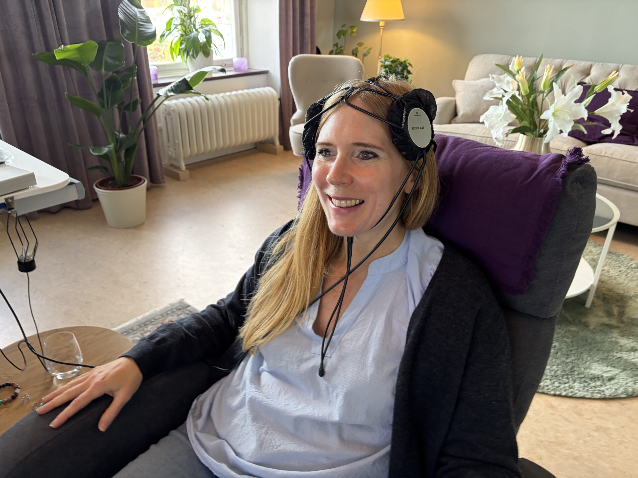 Carolina, reporter för Kurera, testar frekvensterapi med sittande i en fåtölj med sensorer på huvudet