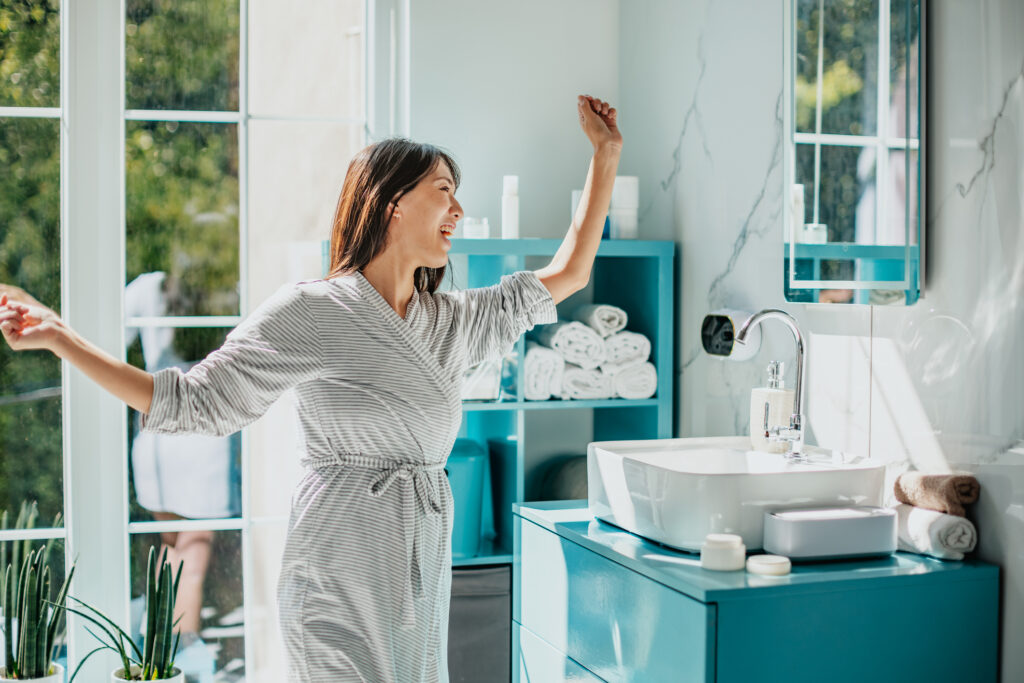 Glad kvinna dansande i badrum