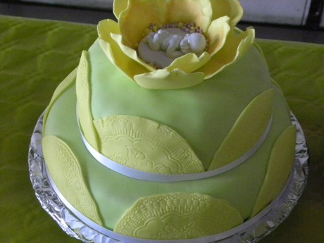 Grön tårta med sovande baby i porslin i blomma av marsipan