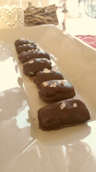 Lakritskola med chokladöverdrag i rad på ett avlångt grått fat