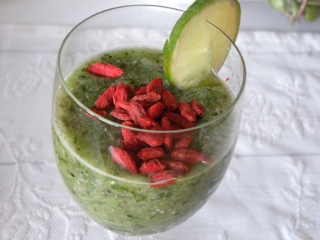 Grön Smoothie i ett glas toppad med gojibär och en limeskiva