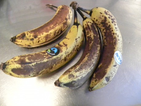 Mogna bruna bananer på ett vitt fat