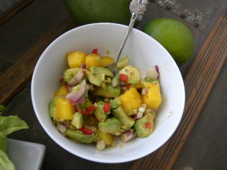 Mango och avocadosalsa i en vit skål på ett brunt bord