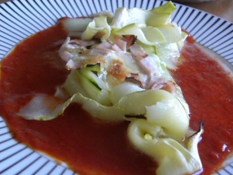 Zucchinigratäng med mozarella på en bädd av tomatsås