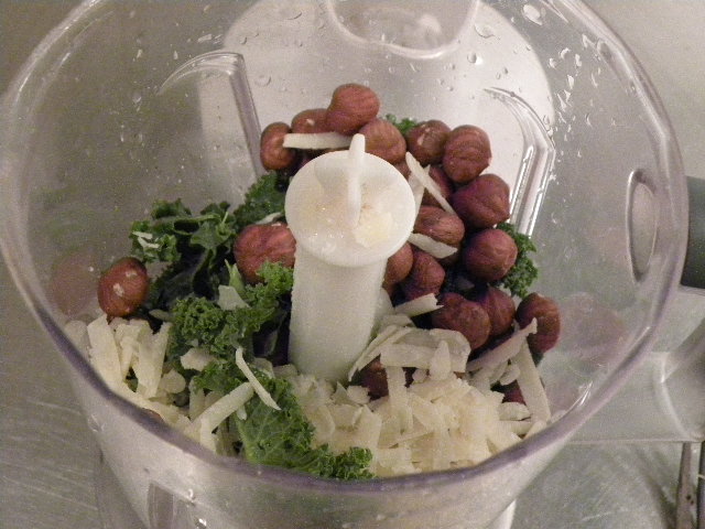 Ingredienser till grönkålspesto i en mixer
